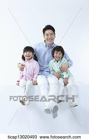 Stock Image - a father sitting with his kids. Fotosearch