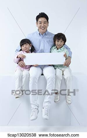 Stock Photo - a father sitting with kids while holding a blank paper. Fotosearch