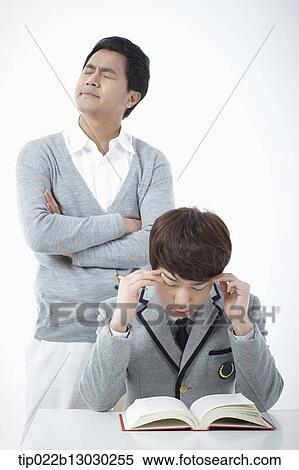 Stock Photography - a father with his son doing homework. Fotosearch