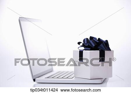 Picture - a gift box on a laptop. Fotosearch