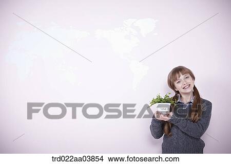 a girl holding a plant View Large Photo Image Picture - a girl holding a plant. Fotosearch