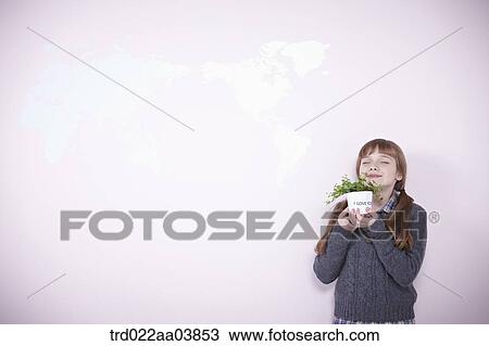 a girl holding a plant View Large Photo Image Stock Image - a girl holding a plant. Fotosearch