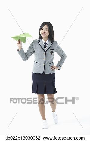 Stock Image - a girl in a school uniform and a paper plane. Fotosearch