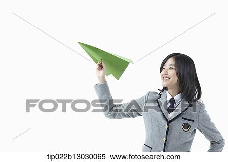 Stock Photography - a girl in a school uniform and a paper plane. Fotosearch
