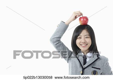 a girl in a school uniform and an apple on her head View Large Photo Image Stock Photo - a girl in a school uniform and an apple on her head. Fotosearch