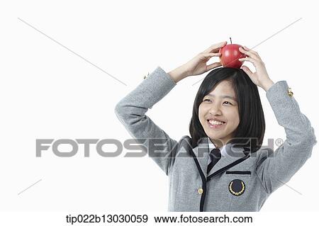 a girl in a school uniform and an apple on her head View Large Photo Image Stock Photo - a girl in a school uniform and an apple on her head. Fotosearch
