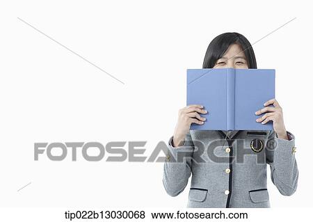 Stock Photo - a girl in a school uniform holding a book. Fotosearch
