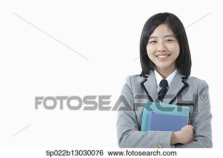 a girl in a school uniform holding books View Large Photo Image Stock Photograph - a girl in a school uniform holding books. Fotosearch