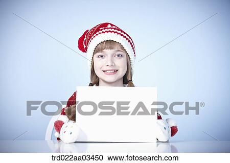 a girl in winter outfit holding a blank board View Large Photo Image Stock Image - a girl in winter outfit holding a blank board. Fotosearch