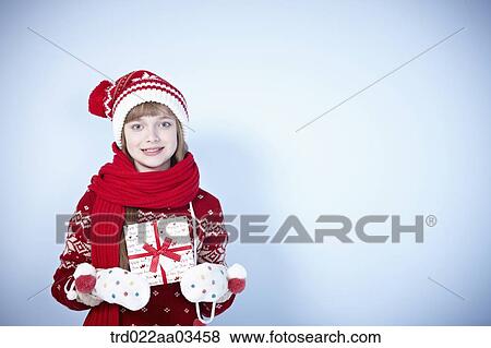 a girl in winter outfit holding a gift View Large Photo Image Stock Photo - a girl in winter outfit holding a gift. Fotosearch