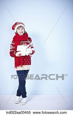 a girl in winter outfit holding a gift View Large Photo Image Stock Photography - a girl in winter outfit holding a gift. Fotosearch