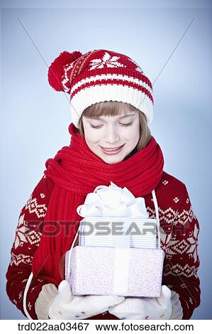a girl in winter outfit holding a pile of gifts View Large Photo Image Stock Photo - a girl in winter outfit holding a pile of gifts. Fotosearch