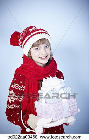 a girl in winter outfit holding a pile of gifts View Large Photo Image Stock Photo - a girl in winter outfit holding a pile of gifts. Fotosearch