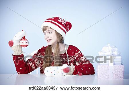 a girl in winter outfit playing with Christmas decoration View Large Photo Image Stock Photo - a girl in winter outfit playing with Christmas decoration. Fotosearch