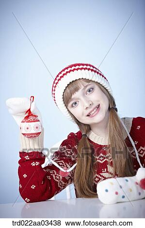 a girl in winter outfit playing with Christmas decoration View Large Photo Image Stock Photo - a girl in winter outfit playing with Christmas decoration. Fotosearch