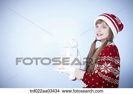 a girl in winter outfit posing with a pile of gifts View Large Photo Image Picture - a girl in winter outfit posing with a pile of gifts. Fotosearch