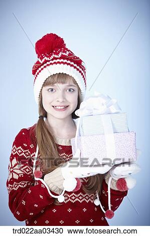 a girl in winter outfit posing with a pile of gifts View Large Photo Image Stock Image - a girl in winter outfit posing with a pile of gifts. Fotosearch