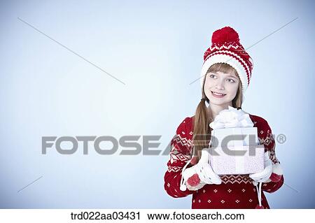 a girl in winter outfit posing with a pile of gifts View Large Photo Image Stock Image - a girl in winter outfit posing with a pile of gifts. Fotosearch