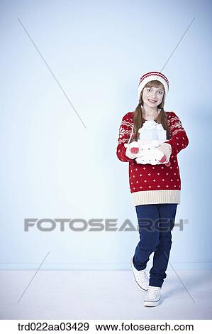 a girl in winter outfit posing with a pile of gifts View Large Photo Image Stock Photo - a girl in winter outfit posing with a pile of gifts. Fotosearch