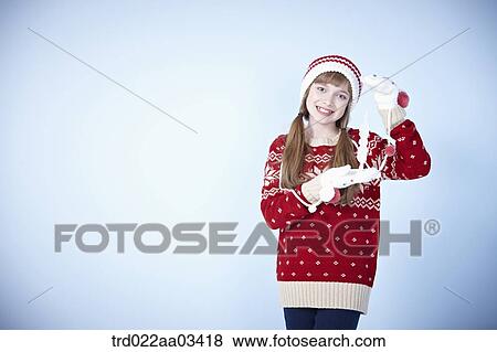 Stock Photo - a girl in winter outfit posing with snowflake. Fotosearch