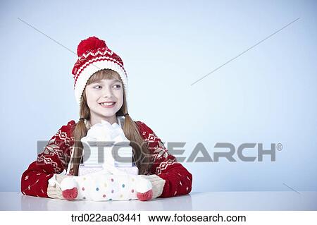 a girl in winter outfit sitting at table with a pile of gifts View Large Photo Image Stock Image - a girl in winter outfit sitting at table with a pile of gifts. Fotosearch