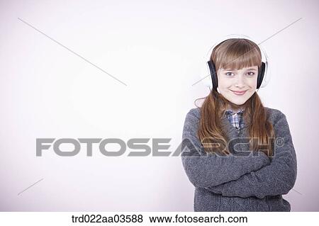 Stock Photo - a girl listening to music with headphone. Fotosearch