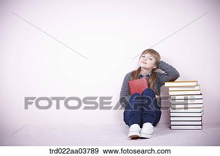 a girl next to several books View Large Photo Image Stock Photo - a girl next to several books. Fotosearch
