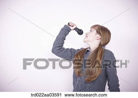 a girl singing a song with microphone View Large Photo Image Stock Image - a girl singing a song with microphone. Fotosearch
