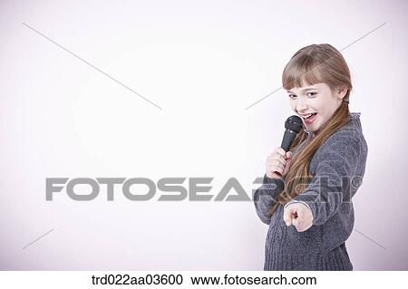 a girl singing a song with microphone View Large Photo Image Stock Image - a girl singing a song with microphone. Fotosearch