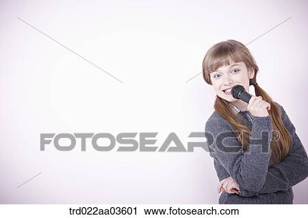 a girl singing a song with microphone View Large Photo Image Stock Image - a girl singing a song with microphone. Fotosearch