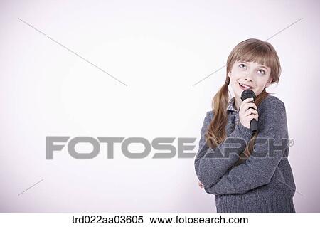 a girl singing a song with microphone View Large Photo Image Stock Photography - a girl singing a song with microphone. Fotosearch