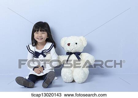 a girl sitting next to a teddy bear View Large Photo Image Stock Image - a girl sitting next to a teddy bear. Fotosearch