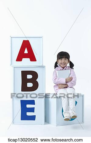 a girl sitting on boxes with alphabets View Large Photo Image Stock Image - a girl sitting on boxes with alphabets. Fotosearch