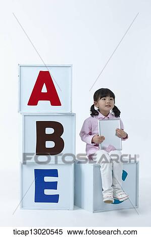 a girl sitting on boxes with alphabets View Large Photo Image Stock Photography - a girl sitting on boxes with alphabets. Fotosearch