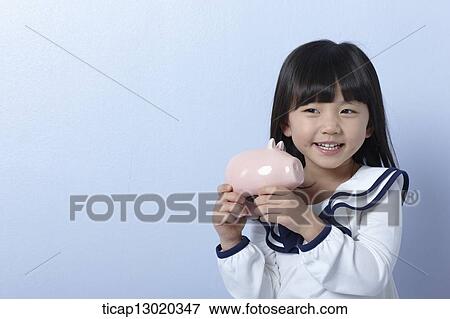 Stock Photo - a girl with a piggy bank. Fotosearch