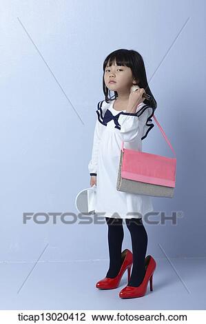 Stock Image - a girl with big heels and a handbag. Fotosearch