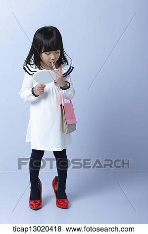 a girl with big heels and a handbag putting on make up View Large Photo Image Stock Photo - a girl with big heels and a handbag putting on make up. Fotosearch