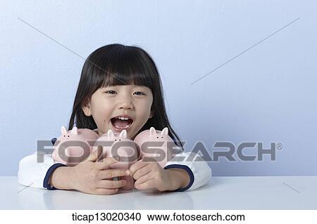 Stock Image - a girl with piggy banks. Fotosearch
