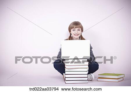 a girl with several books and a laptop View Large Photo Image Picture - a girl with several books and a laptop. Fotosearch