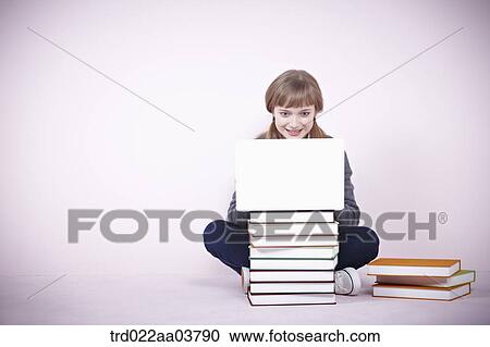 a girl with several books and a laptop View Large Photo Image Stock Image - a girl with several books and a laptop. Fotosearch