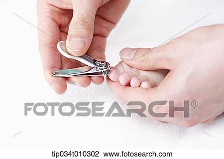 Stock Image - a hand cutting baby's toe nail. Fotosearch