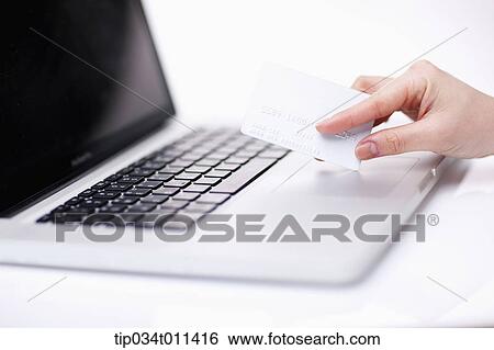 a hand using a laptop holding a card View Large Photo Image Stock Photograph - a hand using a laptop holding a card. Fotosearch