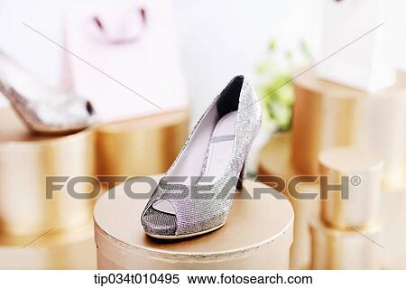 Stock Photography - a high heel on a golden box. Fotosearch