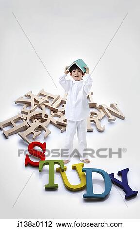 a kid holding a book with a word study View Large Photo Image Stock Image - a kid holding a book with a word study. Fotosearch