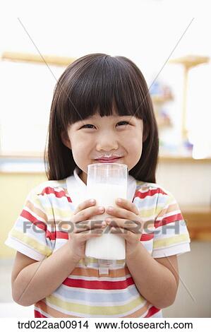 Picture - a kid holding a glass of milk. Fotosearch