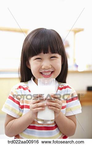 Stock Photograph - a kid holding a glass of milk. Fotosearch