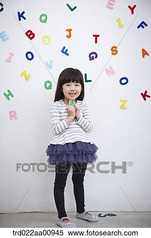 Stock Photography - a kid playing with alphabet blocks on the wall. Fotosearch