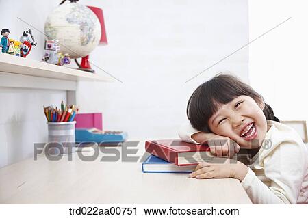 a kid smiling while leaning on a pile of books View Large Photo Image Stock Image - a kid smiling while leaning on a pile of books. Fotosearch