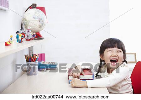 a kid smiling while studying at table View Large Photo Image Picture - a kid smiling while studying at table. Fotosearch