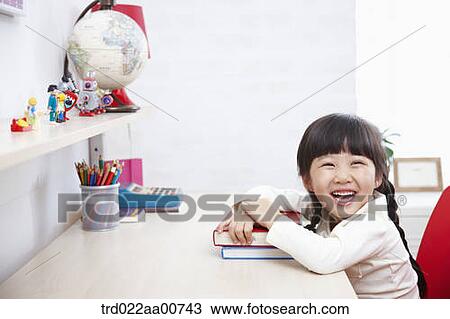 a kid smiling while studying at table View Large Photo Image Stock Image - a kid smiling while studying at table. Fotosearch